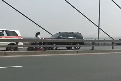 Nữ sinh đầu trần, phóng xe đạp điện ngược chiều trên cầu Nhật Tân