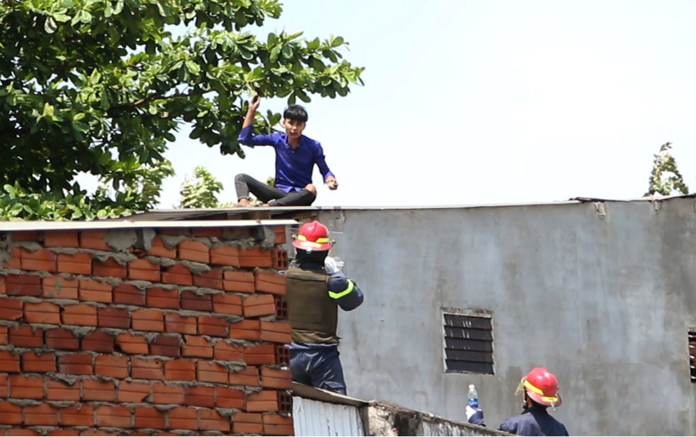 Thanh niên nghi ngáo đá leo nóc nhà dân, tấn công cảnh sát