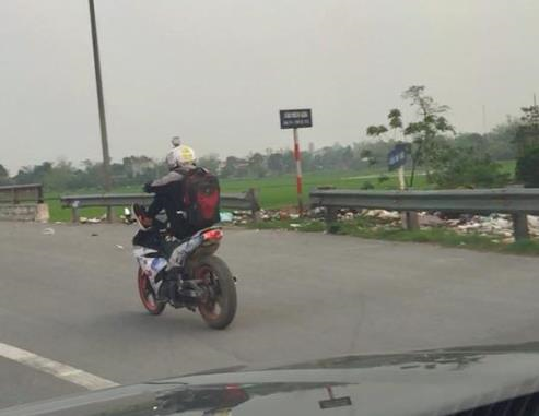 Nam thanh niên thản nhiên lái xe máy bằng chân trên quốc lộ