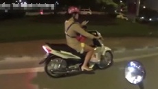 Cô gái liều lĩnh, vừa chở con vừa bấm điện thoại khi đi xe máy