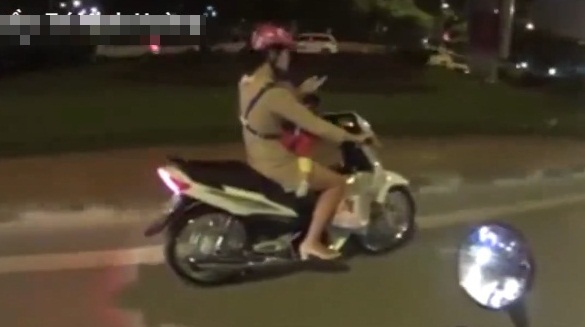 Cô gái liều lĩnh, vừa chở con vừa bấm điện thoại khi đi xe máy