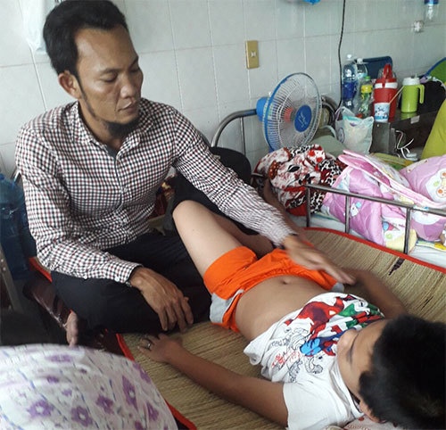 Người cha khổ đau chăm đứa con trong bệnh viện