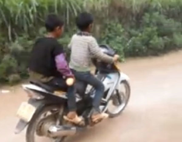 Hai cậu bé vùng cao phối hợp nhịp nhàng giúp nhau đi xe máy