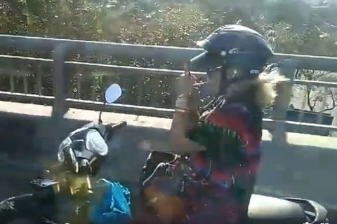 Nữ 'ninja' lái xe máy buông 2 tay, châm thuốc lá hút trên cầu