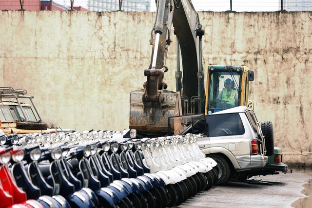 Dùng máy xúc nghiền nát hơn trăm xe hơi nhập lậu