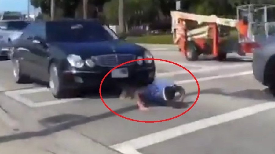 Thanh niên liều chết chui gầm ô tô, chống đẩy giữa phố đông