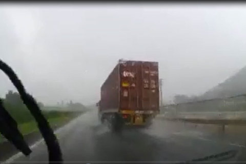 Kinh hoàng nước bắn từ xe tải trùm kín xe con giữa trời mưa bão