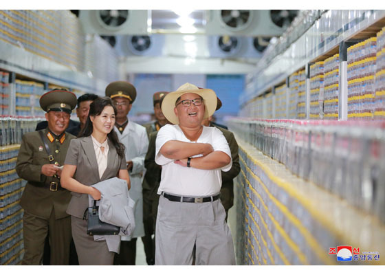 Vợ Kim Jong Un tươi tắn cầm áo khoác cho chồng