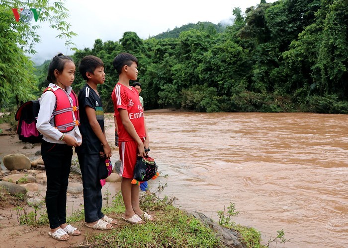 Học sinh chui túi nilon vượt suối lũ tới trường ở Điện Biên