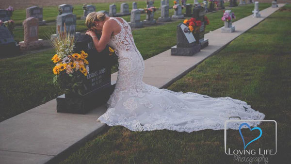 Cô dâu mặc váy cưới chụp ảnh bên mộ hôn phu