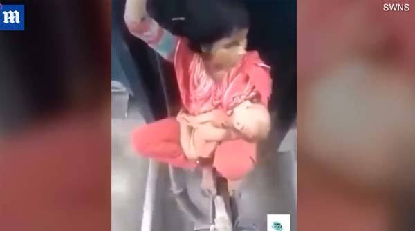 Xem mẹ trẻ bế con ngồi 'vắt vẻo' giữa hai toa tàu
