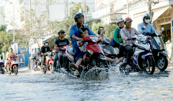 Triều cường đạt đỉnh, dân Sài Gòn cao gối, bịt mũi lội nước thối về nhà