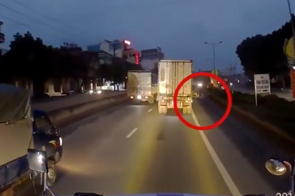 Người phụ nữ đi xe máy thoát chết đầy may mắn dưới bánh xe container