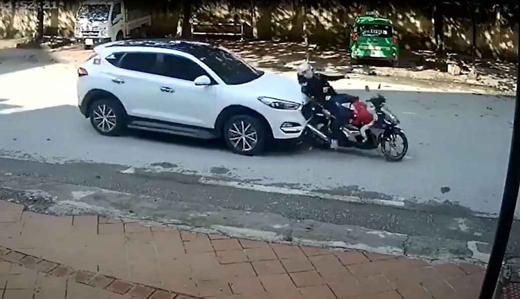 Dừng chờ đèn đỏ, hai mẹ con đi xe máy bất ngờ bị ô tô tông ngã