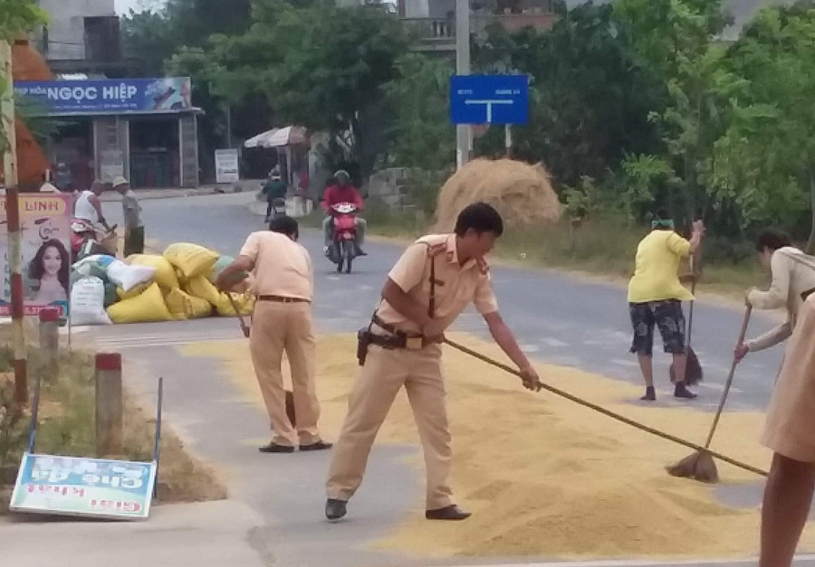 Cảnh sát giao thông Quảng Trị nhắc nhở và giúp bà con gom thóc trước cơn giông