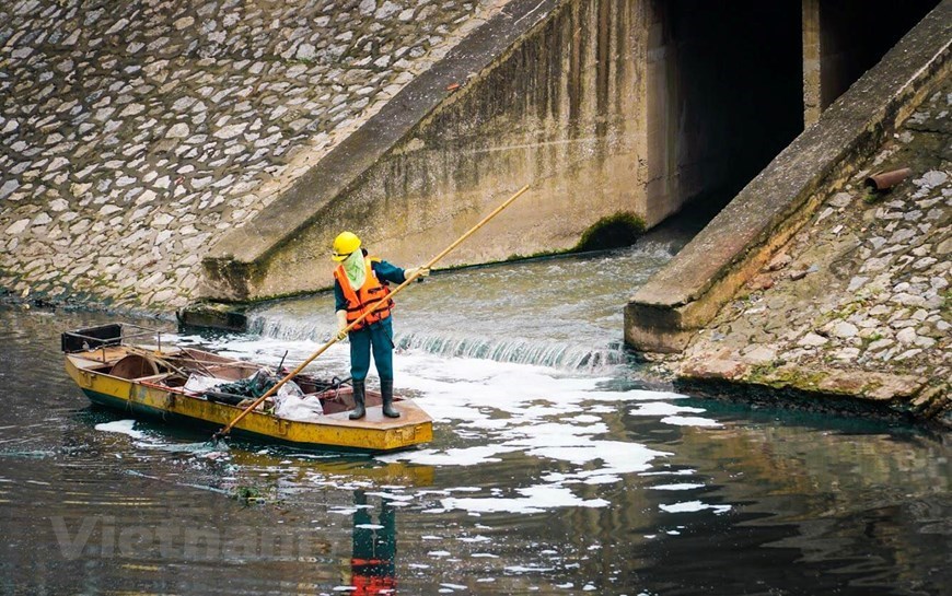 Environment workers clean up To Lich river