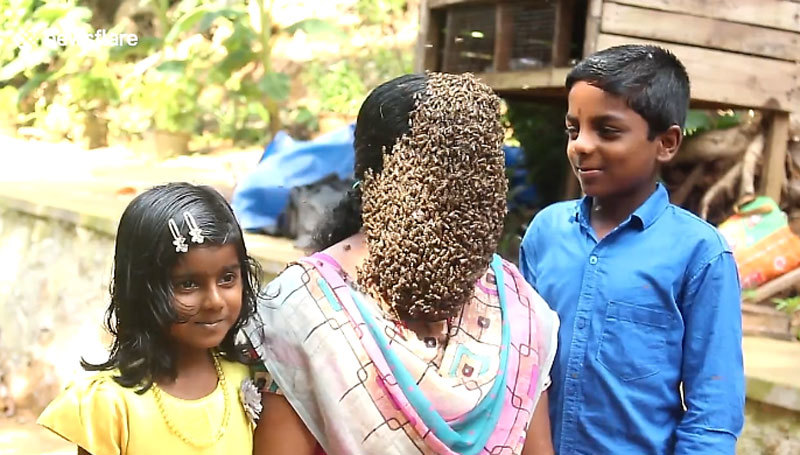 Xem bà mẹ Ấn Độ thản nhiên cho ong bu kín mặt cạnh các con