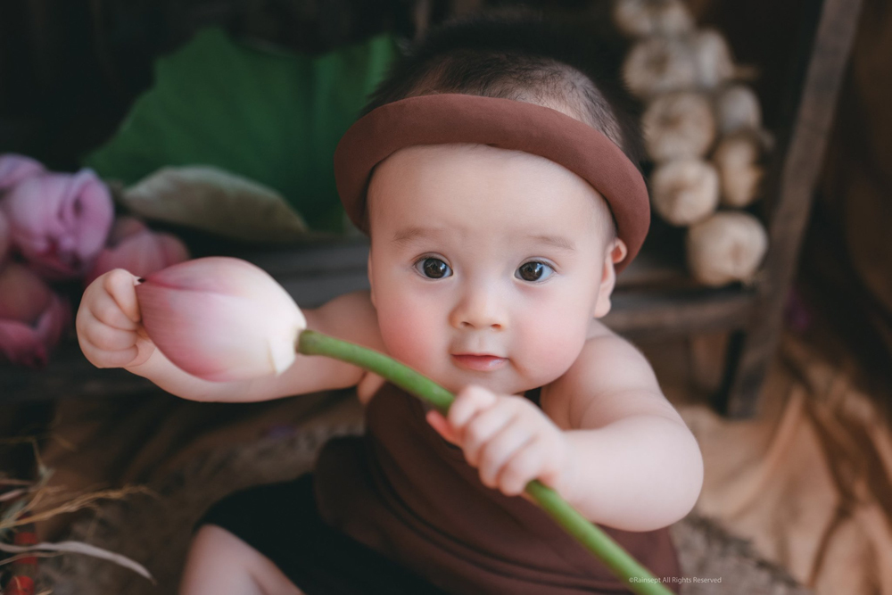 Hoa sen, Em be trai: Đây là hình ảnh của một em bé trai được đặt bên cạnh hoa sen tuyệt đẹp. Hãy chiêm ngưỡng vẻ đẹp mộc mạc của em bé đáng yêu và sắc hoa sen cùng những ý nghĩa tuyệt vời mà nó mang lại.