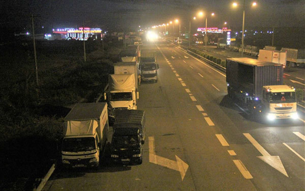 Long-haul truck drivers illegally park on highway to sleep