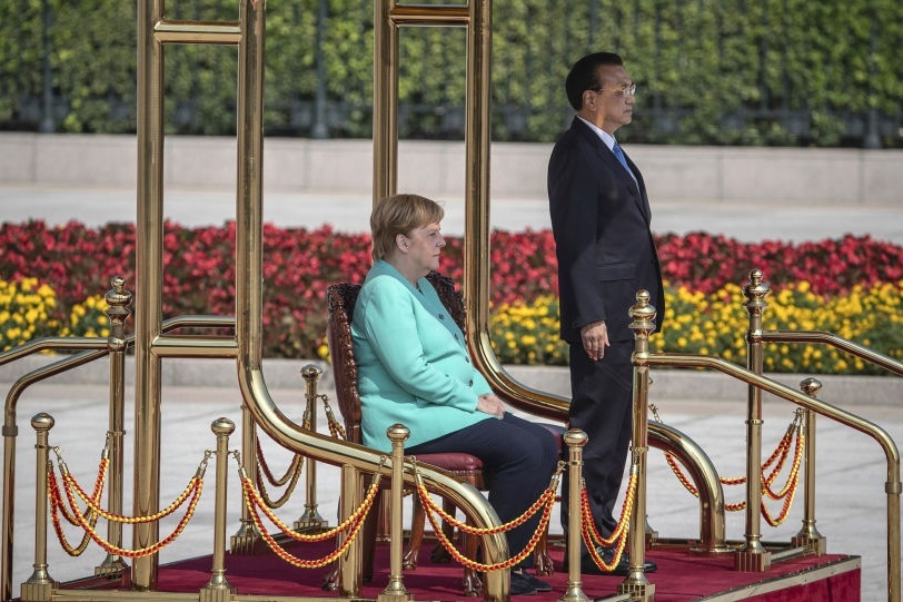 Thủ tướng Đức Merkel ngồi trong lễ chào cờ khi thăm Trung Quốc