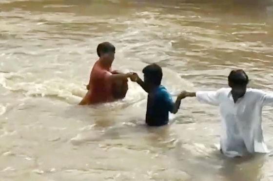 Xem dân làng tạo 'dây chuyền người' giải cứu bé gái giữa nước lũ cuồn cuộn