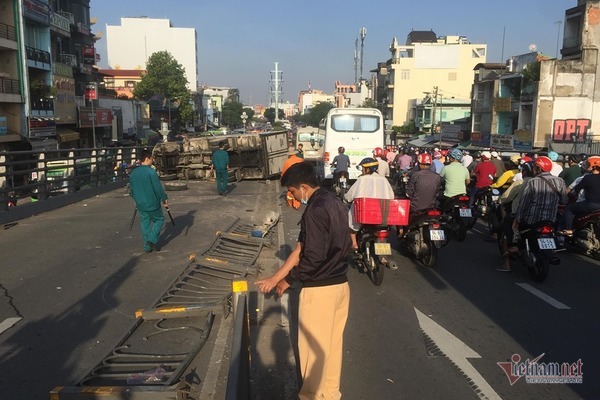 Xe tải lật trúng 2 xe máy, ép cô gái kẹt cứng vào thành cầu ở Sài Gòn