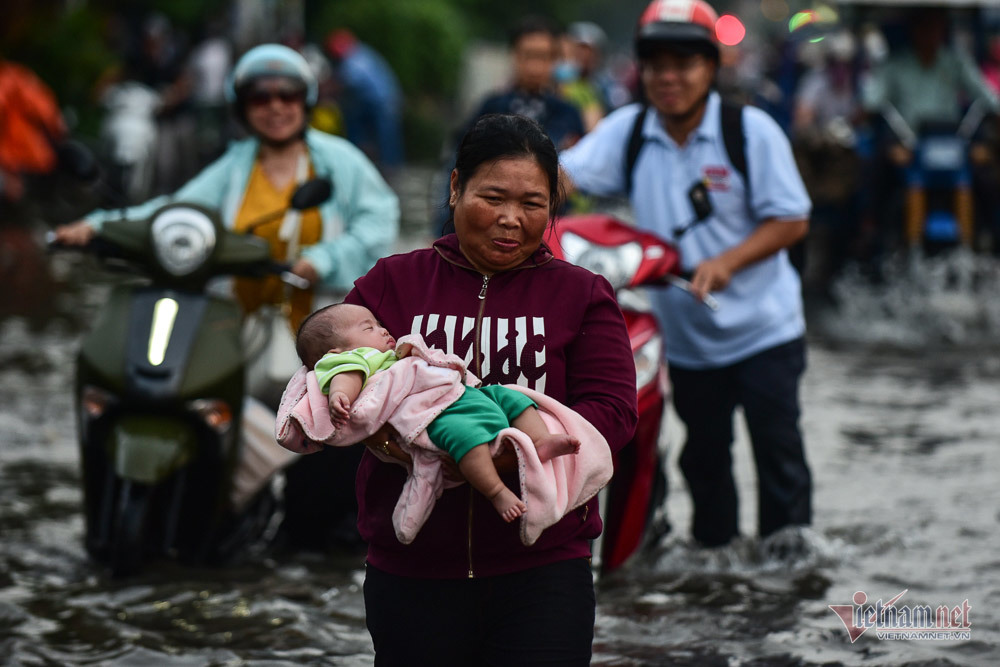 Mẹ bồng con mò mẫm lội đường Sài Gòn ngày triều cường kỷ lục
