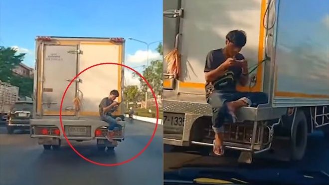 Người đàn ông ngồi chênh vênh phía sau xe tải đang chạy