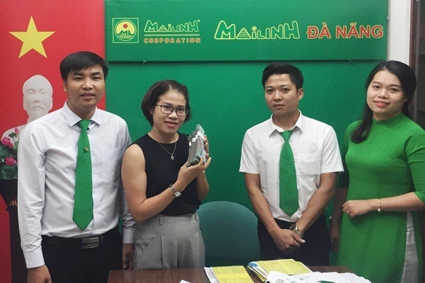 Nữ hành khách nhận lại túi xách đựng số tiền lớn từ tài xế taxi