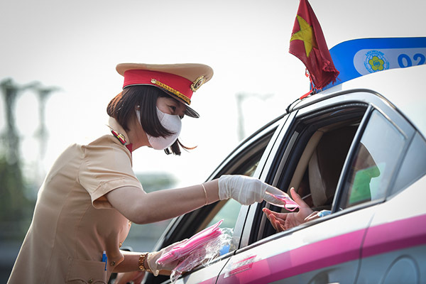 Nữ cảnh sát đội nắng phát khẩu trang ở cửa ngõ Tân Sơn Nhất