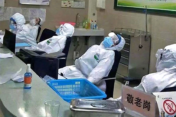 Hình ảnh các bác sĩ ngủ gục vì chống virus corona làm lay động lòng người