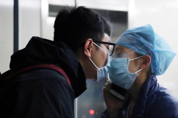 Nữ y tá hôn bạn trai qua tấm kính cách ly gây xúc động mạnh