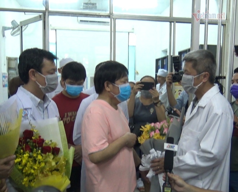 Thứ trưởng Bộ Y tế và Giám đốc BV Chợ Rẫy tặng hoa và trao giấy ra viện cho bệnh nhân. Ảnh: Thanh Tùng