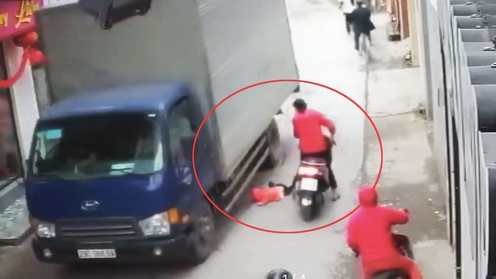 Hà Nội: Mẹ lái xe máy, để con gái rơi ngã trước bánh xe tải