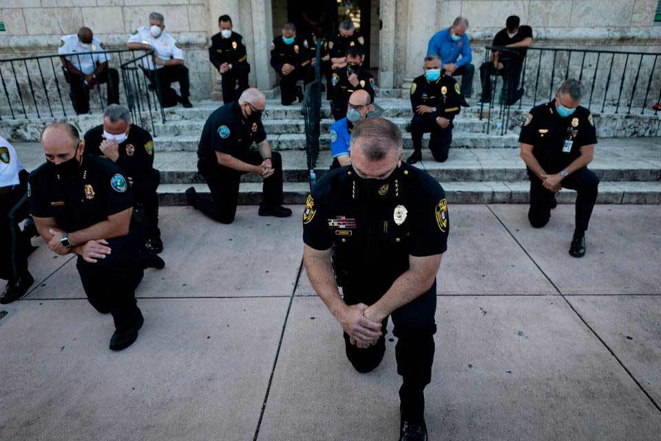 Cảnh sát Mỹ quỳ gối, ôm người biểu tình thể hiện tình đoàn kết