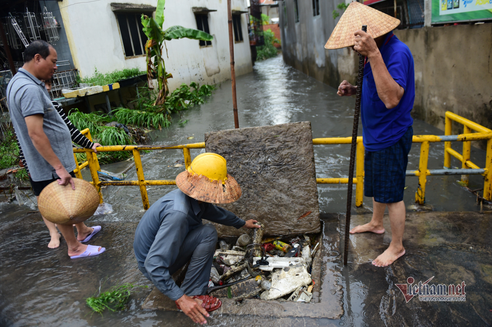 Mưa tối trời 30 phút, dân Sài Gòn móc cống dọn rác, dìu nhau qua đường ngập