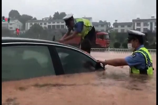 Cảnh sát TQ đập kính chắn gió ôtô cứu người mắc kẹt trong lũ