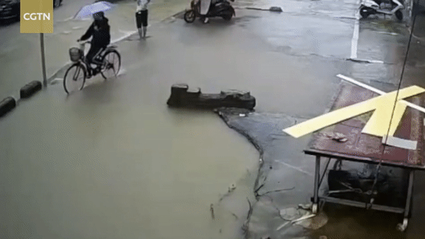 Cô gái đi xe đạp bị hố nước sâu 'nuốt chửng' giữa phố
