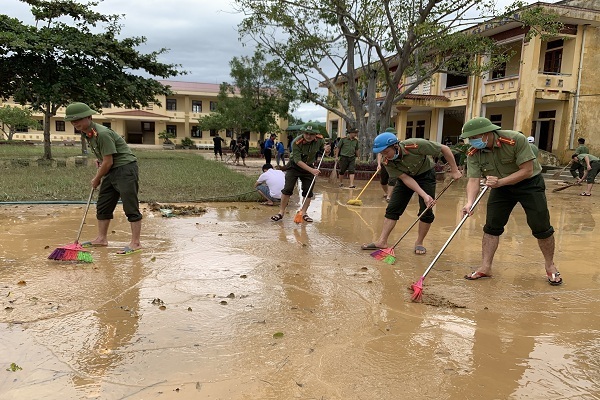 Công an, bộ đội giúp người dân dọn bùn sau lũ lụt ở Quảng Bình