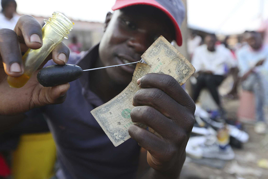 Nghề vá tiền rách làm ăn phát đạt ở Zimbabwe