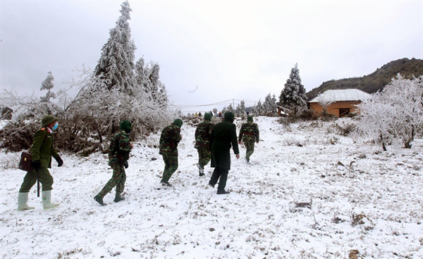 Mountain border turn white with snow, border guards work harder