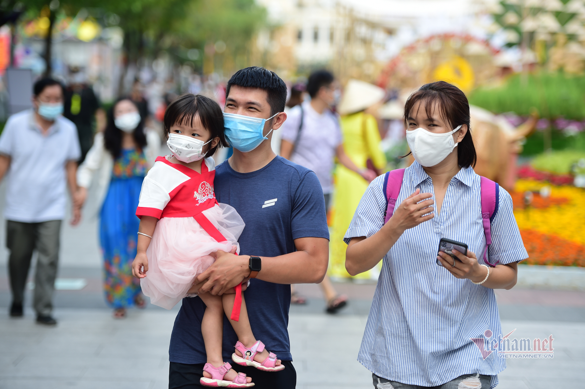 Người Sài Gòn đeo khẩu trang du xuân, tạo dáng bên đường hoa Nguyễn Huệ