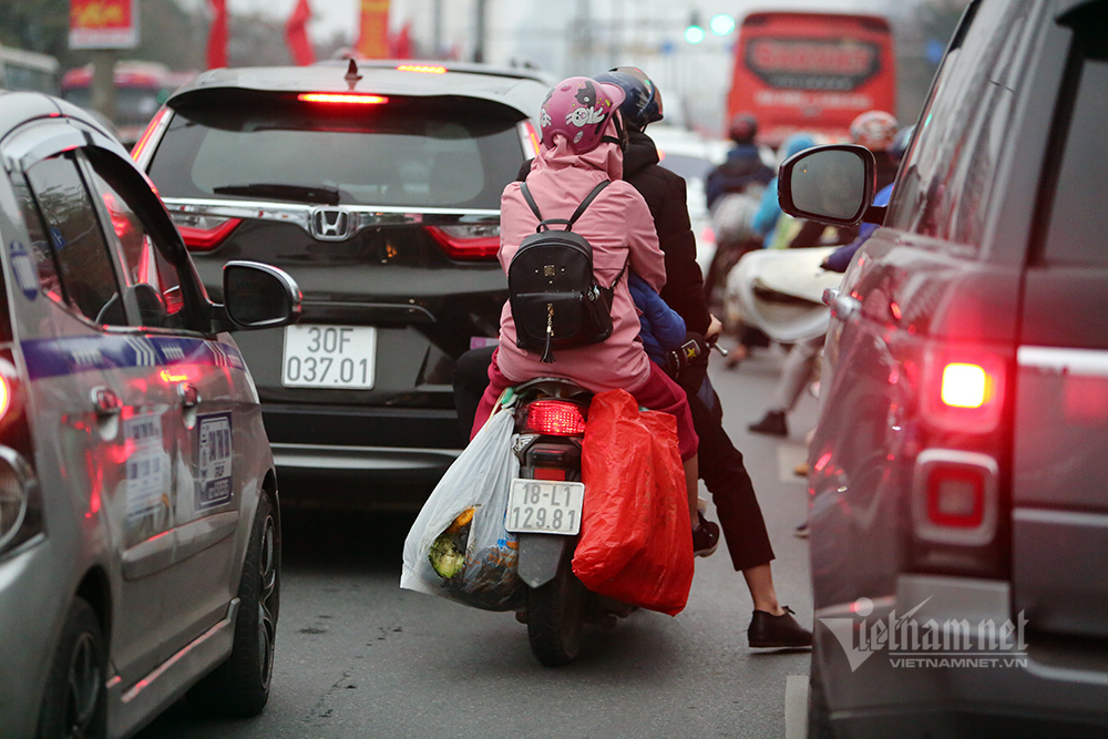 Những em bé sau lưng bố mẹ về lại Thủ đô sau Tết