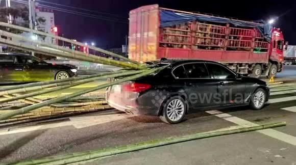 Xe tải phanh gấp khiến nhiều thanh tre rơi xuống đâm xuyên ô tô phía trước