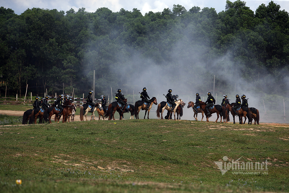 Cảnh sát kỵ binh đổ người bắn súng hai tay trên lưng ngựa