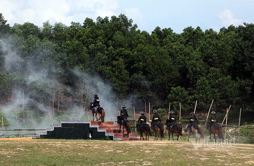 Cảnh sát kỵ binh đổ người bắn súng hai tay trên lưng ngựa