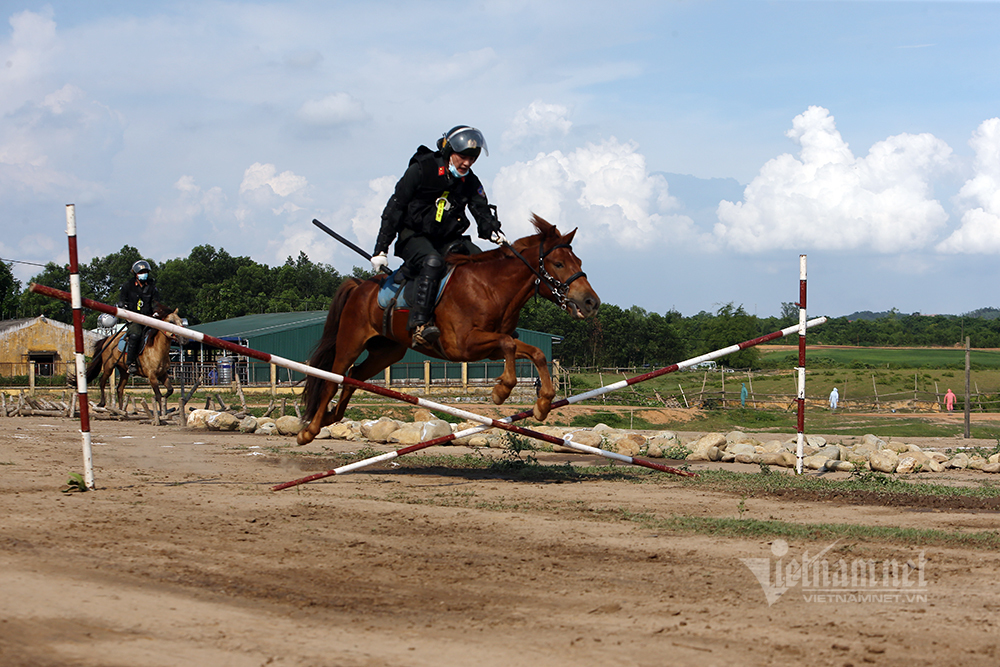 Cảnh sát kỵ binh đổ người bắn súng hai tay trên lưng ngựa