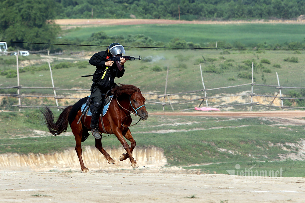 Cảnh sát kỵ binh đổ người bắn súng hai tay trên lưng ngựa