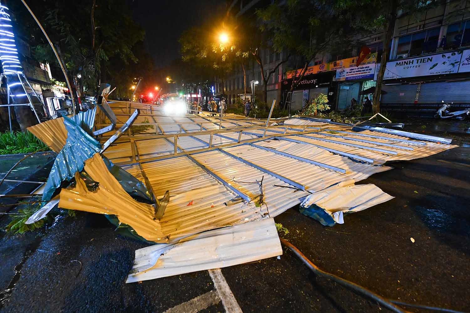 Mưa giông ở Hà Nội thổi mái tôn bay xuống, rơi trúng ô tô đỗ ven đường