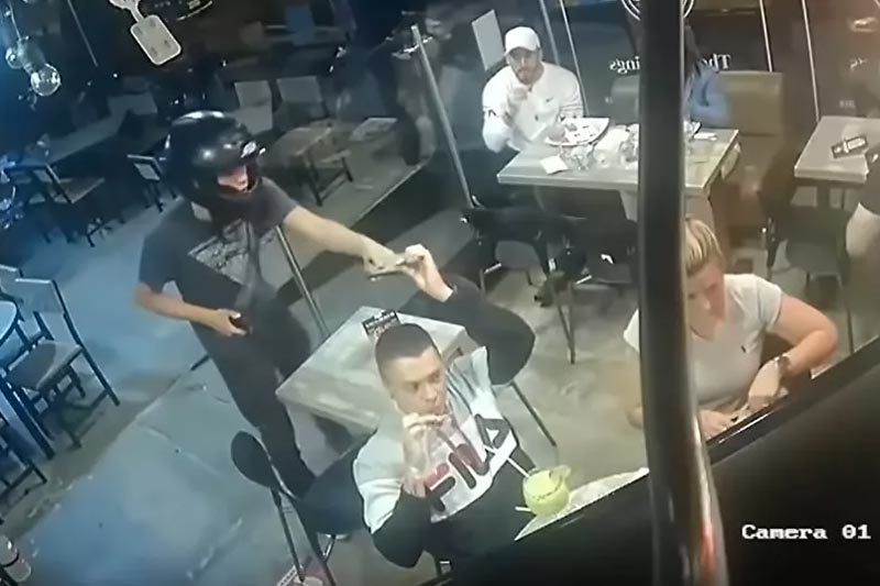 Mải mê ăn cánh gà bất chấp kẻ cướp chĩa súng sau lưng